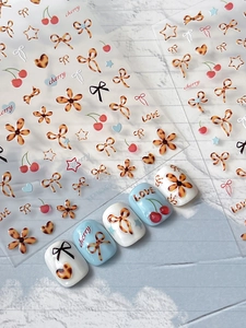 Vue détaillée d'autocollants pour ongles cerise et nœud avec motifs léopard marron