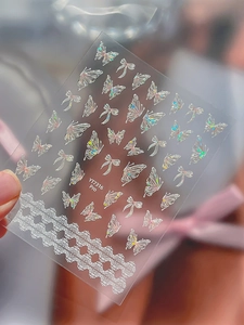 Macro view of Aurora butterfly nail stickers with holographic bows and lace details