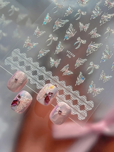 Macro view of 3D iridescent butterfly and lace nail art stickers with laser finish effect