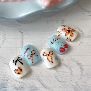 Stickers ongles ambre gelée avec cerises 3D et nœuds en écaille sur base blanche