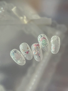 Macro shot of 5 Christmas press-on nails with pink bows, reindeer, and 3D glitter details