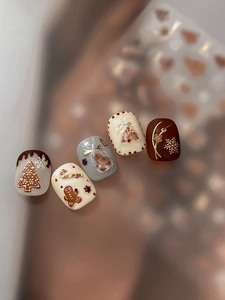 Detailed relief nail art showing gingerbread man, Christmas tree and snowflake designs