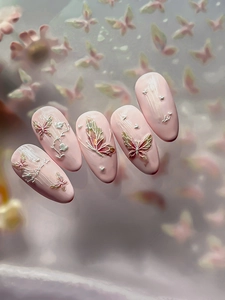 Detailed macro view of 3D butterfly embossed nail charms with pink purple fairy designs