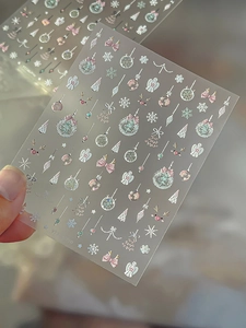 Detail showing pink and silver Christmas nail stickers with snowflakes and reindeer