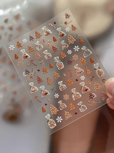 Macro detail of 3D embossed Christmas nail stickers with gingerbread men and trees