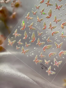 Macro detail of holographic butterfly nail stickers with pearlescent shimmering gradients