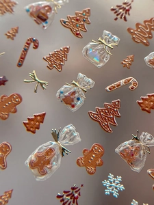 Macro detail of 3D gold embossed Christmas nail stickers with gingerbread man and trees