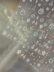 Detailed macro view of 3D embossed Christmas nail stickers with iridescent pearl finish
