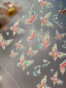 Close-up of 3D embossed butterfly nail art sticker with holographic laser effect and floral patterns