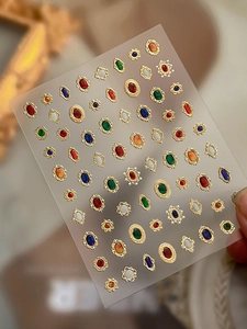 Dettaglio di adesivi 3D per nail art con gemme vintage e bordi eleganti in lamina d'oro