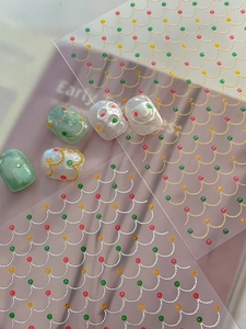 Detailed close-up of 3D embossed Christmas nail stickers with gold wavy lines and stars