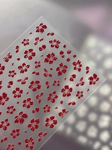 Macro shot of 5D embossed deep red floral nail art stickers with 3D texture details