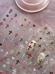 Macro detail of embossed plaid heart and cross nail art stickers on a sample manicure