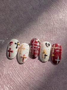 Macro view of gothic embossed nail art patches with chrome cross and textured patterns