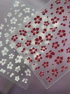 Macro view of 3D embossed floral nail stickers featuring red and white flower textures