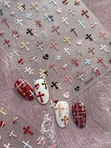 Detailed macro view of relief cross and heart nail art stickers with plaid patterns