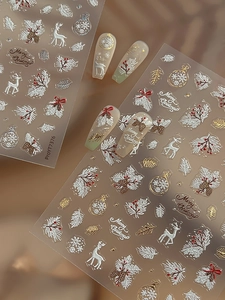 Makro-Detail von 5D-geprägten Weihnachts-Nagelstickern mit Rentier- und Stechpalmen-Motiven
