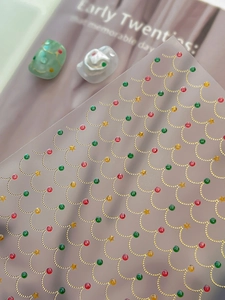 Detail of Christmas nail stickers with gold wavy lines and red green stars decoration