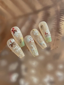 Detail von Weihnachts-Nailart mit weißen geprägten Rentier- und Schneeflockenmustern