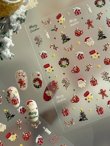 Macro detail of 5D embossed Christmas nail stickers featuring Santa Claus and gingerbread men