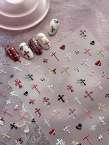 Detail of gothic cross and heart nail stickers with red plaid textures and metallic finish
