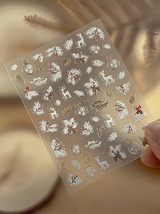 Details von 3D-geprägten Weihnachts-Nagelstickern mit goldenen Rentier- und Kiefernzweigen