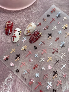Detail shot of YT7478 cross and heart nail art stickers applied on red and white nails