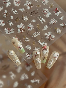 Makro-Detail von 3D geprägten Weihnachts-Nagelstickern mit Goldhirsch- und Schneeflocken