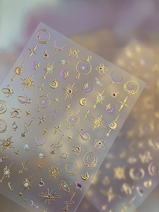 Detail of gold moon and star nail art stickers with embossed celestial patterns