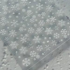 3D embossed snowflake nail art stickers with intricate white patterns for Christmas manicure