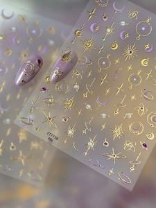 Detail of 3D gold embossed star and moon nail stickers with celestial planet designs