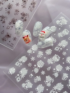 Dettaglio degli adesivi per unghie natalizi 3D con fiocchi di neve e motivi di Babbo Natale