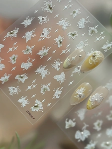 Detailed view of 3D butterfly nail stickers with star motifs and pearl accents