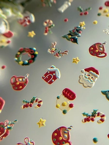Detailed macro view of 3D embossed Christmas nail stickers with Santa and reindeer motifs
