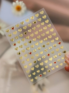 Detailed view of 3D gold and red heart nail art stickers with various textures on film