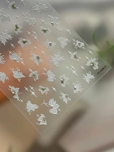 Detailed sheet of embossed butterfly and pearl nail art decals with star patterns