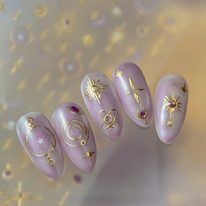 Luxury almond press-on nails with purple pearl finish and golden 3D celestial motifs