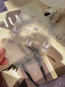 Macro shot of 3D purple bow nail art decals with silver edges on SIS YT7306 card