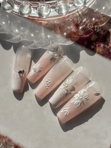 Détail d'ongles forme cercueil avec fleurs en relief 3D et perles sur dégradé de rose