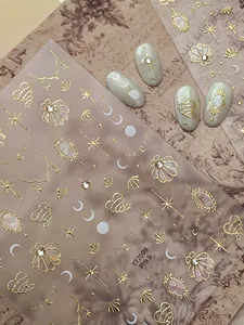 Detail of Rococo nail stickers with gold relief stars and shells on ivory fake nails