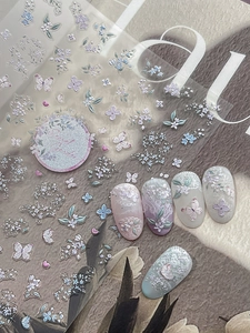 Macro shot of 3D embossed floral nail stickers with butterflies and glitter finish