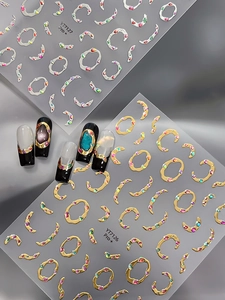 Détail de stickers à ongles 3D métalliques avec anneaux dorés et argentés et strass colorés
