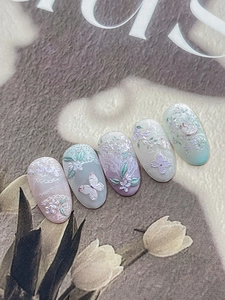 Macro detail of 3D embossed floral and butterfly nail stickers with French lace texture