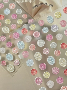 Detail of 3D embossed nail stickers featuring pastel roses, hearts, and wax seal designs