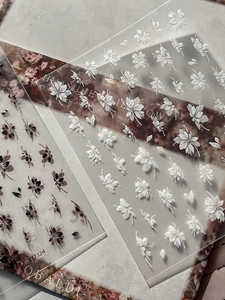 Détails macro d'autocollants 5D pour ongles avec motifs floraux blancs et sombres