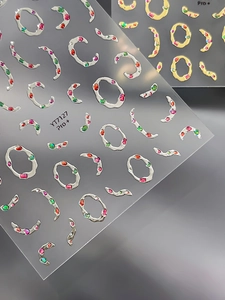 Détails macro de stickers ongles 3D métallisés avec cadres argentés et strass colorés