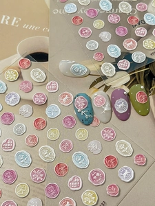 Close-up of 3D embossed wax seal nail stickers with pink roses and bow designs
