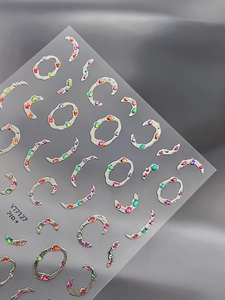 Gros plan de stickers à ongles argentés avec strass irisés et formes de lune en métal