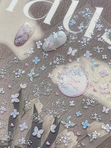 Close-up of Secret Garden embossed nail stickers featuring purple flowers and butterflies