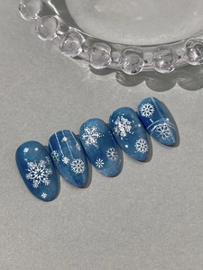 Macro detail of blue winter snowflake nail stickers with holographic glitter and 3D relief